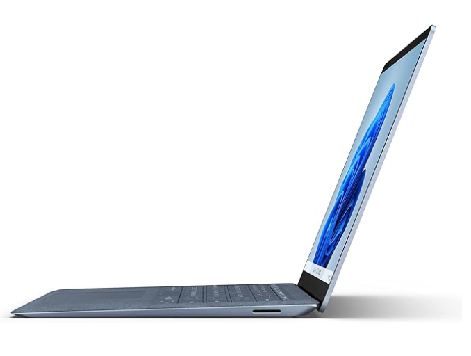 Ordinateur portable leger et performant avec clavier gris, vu de profil, écran affichant une image de paysage.